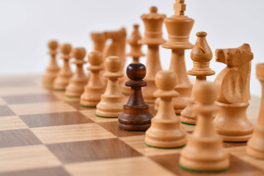 Pion catur di papan permainan sebagai simbol kendali dan strategi